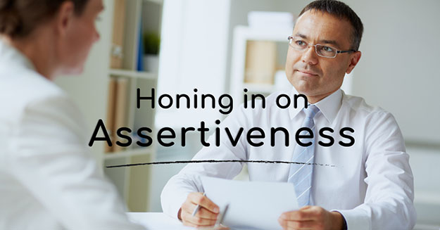 Two men in a conversation with the words homing in on assertiveness.