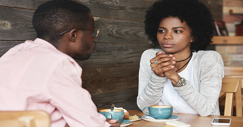 Picture of a man and a woman sitting at a table together in conversation.