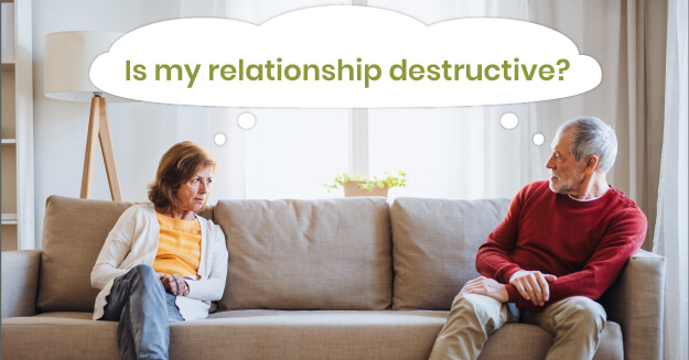 A man and a women seated at opposite ends of a couch with the words is my relationship destructive.